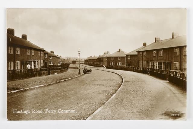 Sepia postcard of Hastings Road, Perry Common, curving between new houses, with a motorbike and sidecar on the road