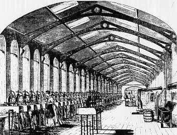 Engraving of a long factory hall under a glazed roof, with rows of workers at benches.