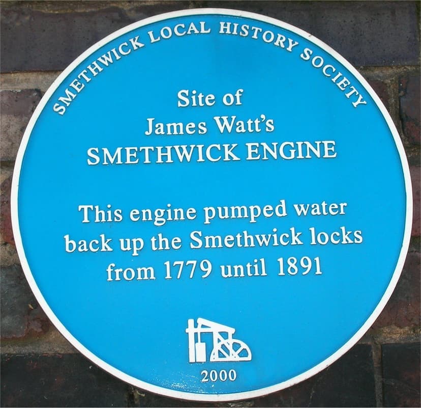 A round blue plaque on a brick wall.