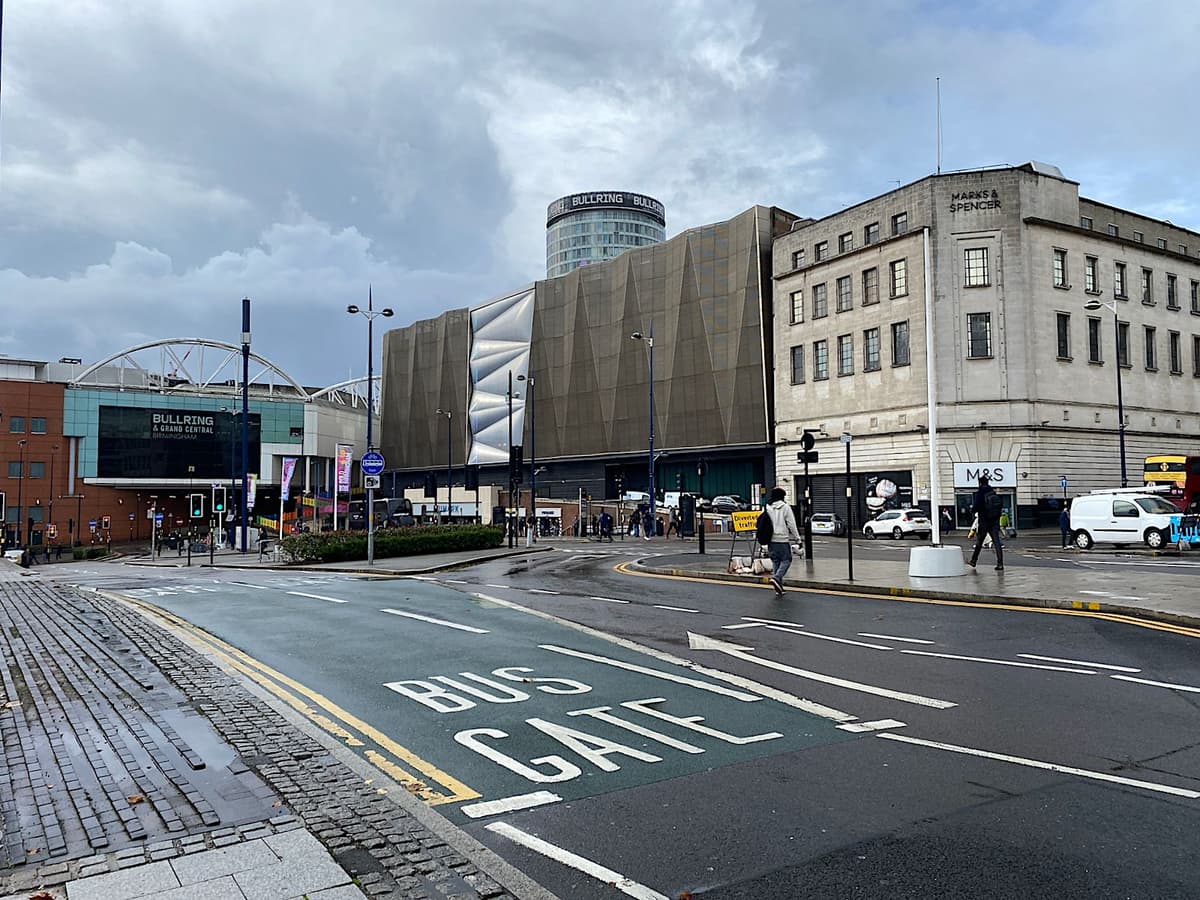 A street-level city road with pavements and new buildings.