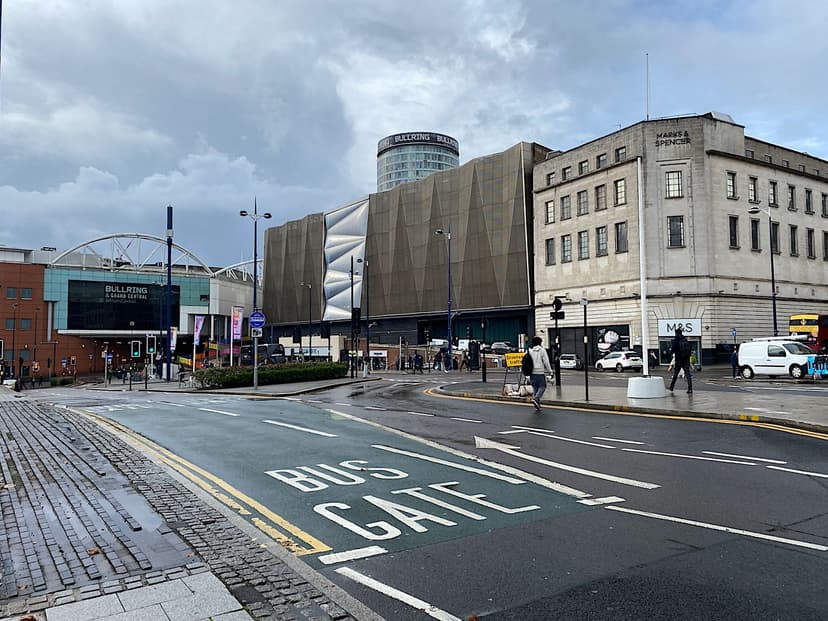 A street-level city road with pavements and new buildings.