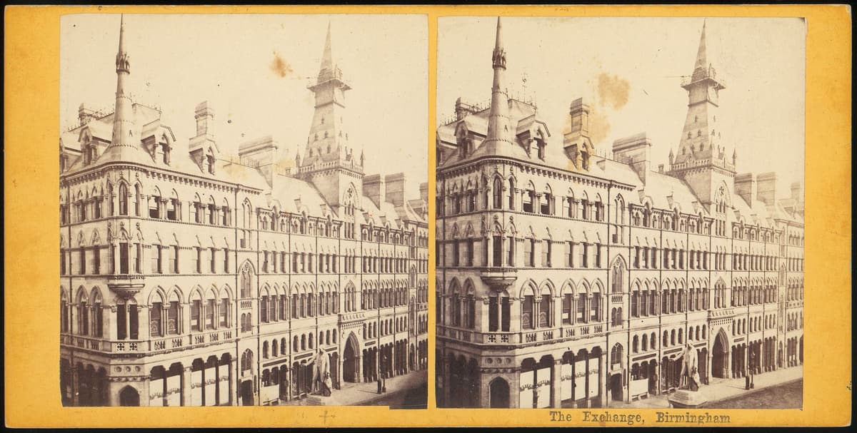Victorian stereo photograph of a Gothic building with a corner spirelet and a clock tower with a spire.