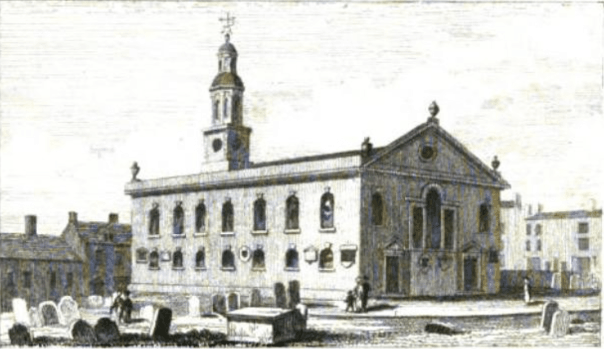 Engraving of a plain brick Georgian church with two rows of arched windows, a pedimented gable with urns and a small domed clock turret, among gravestones.