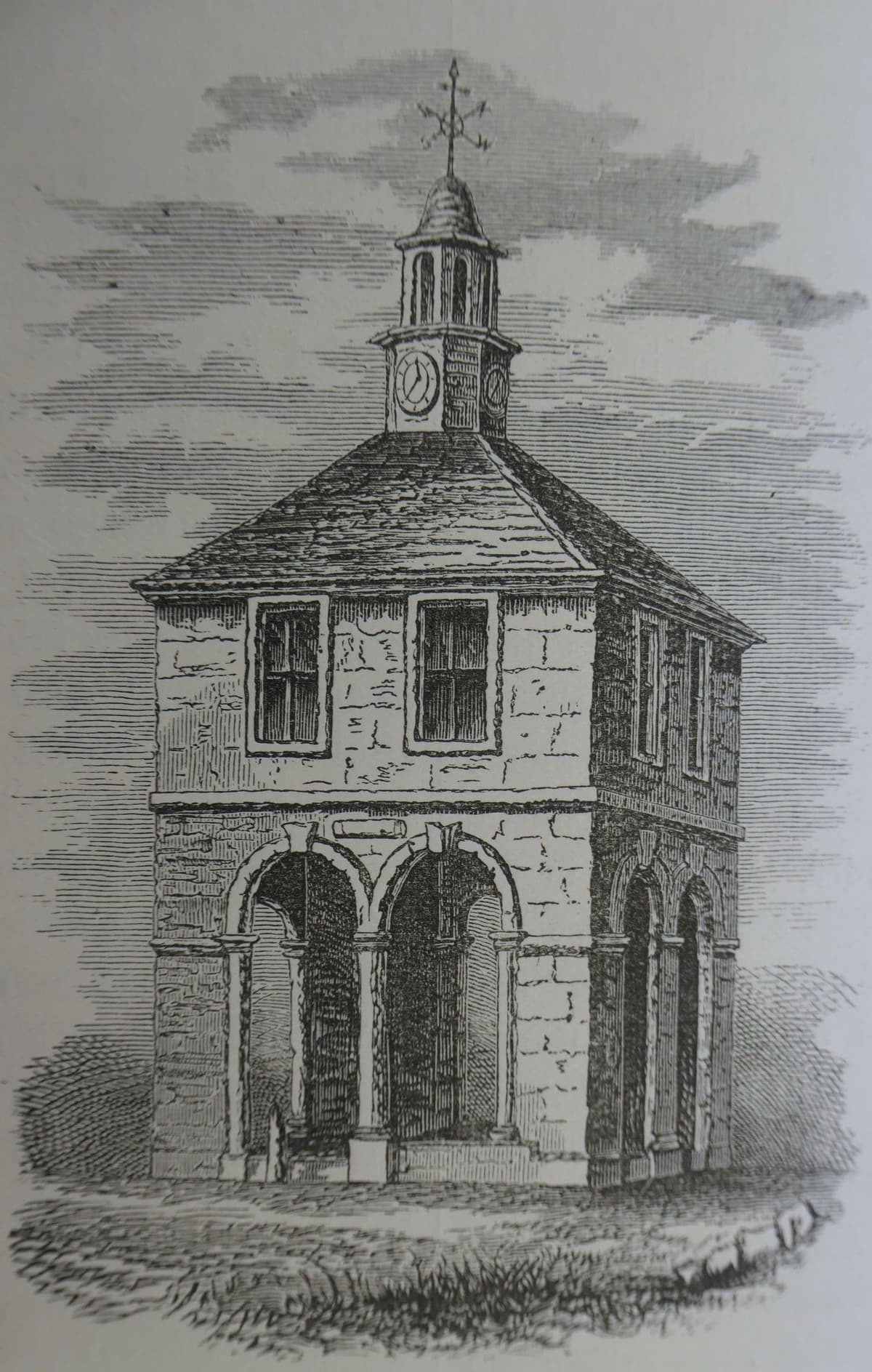 Engraving of a small square market house raised on steps, with open arches below, a hipped roof and a clock turret with a cupola.
