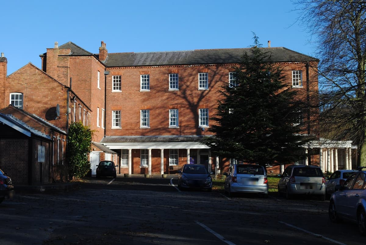 Maryvale House — a long three-storey red-brick Georgian house with a white colonnaded porch, in winter sunshine