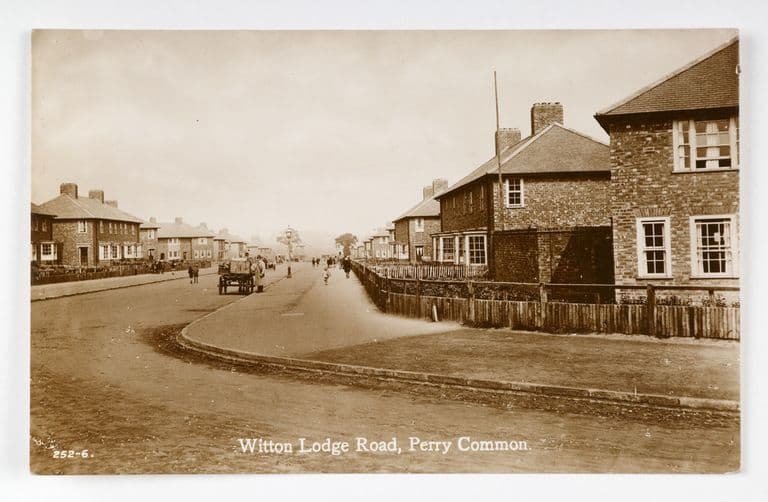 Sepia postcard of Witton Lodge Road, Perry Common: new brick houses behind wooden fences and a horse and cart on the long road