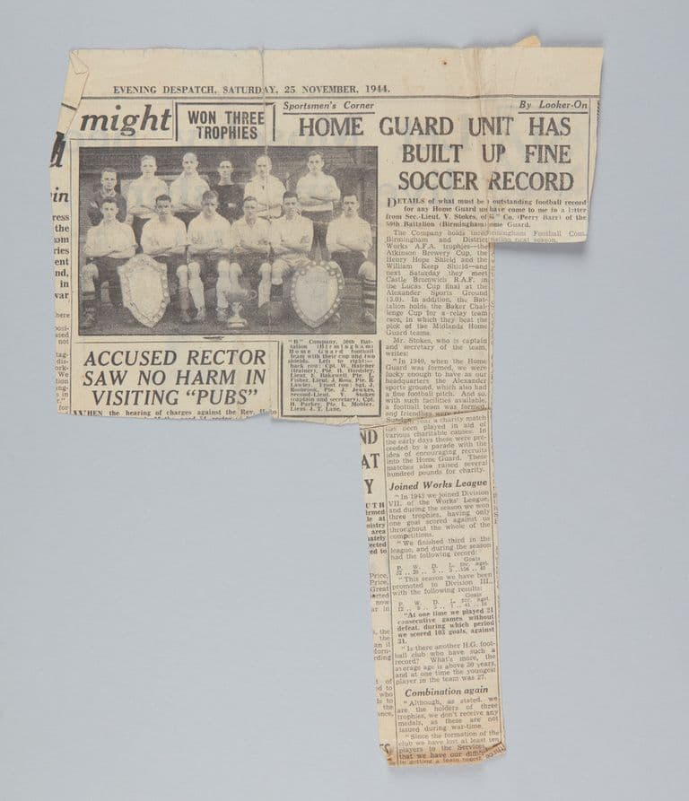 Yellowed newspaper cutting headed 'Home Guard unit has built up fine soccer record', with a photo of a football team in two rows behind two shields and a cup.