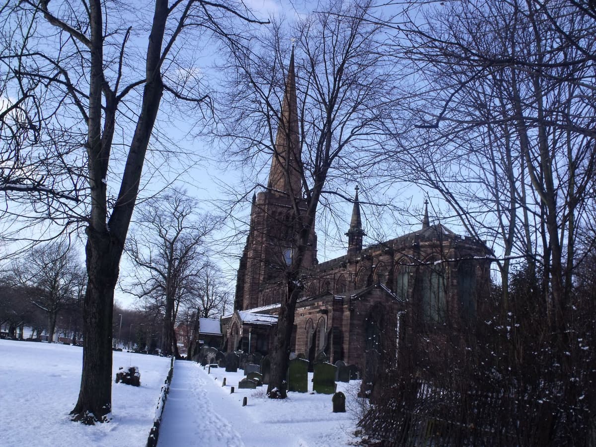 Aston parish church with its tall spire, in snow.