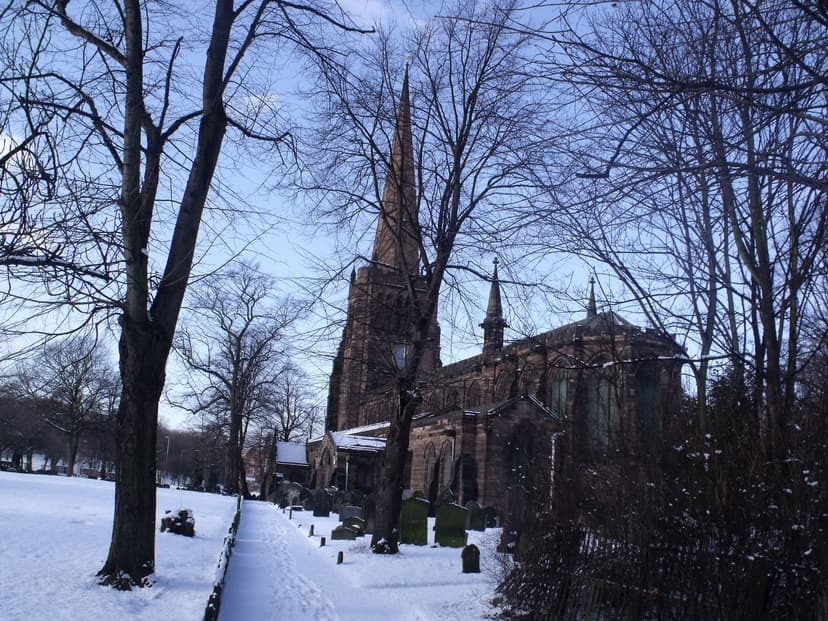 Aston parish church with its tall spire, in snow.