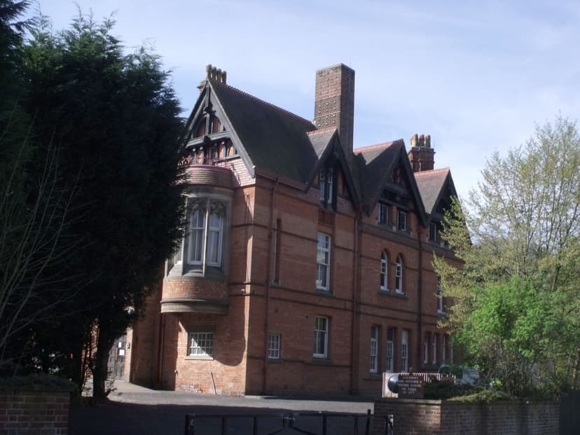 Red-brick Gothic mansion with gables and tall chimneys.