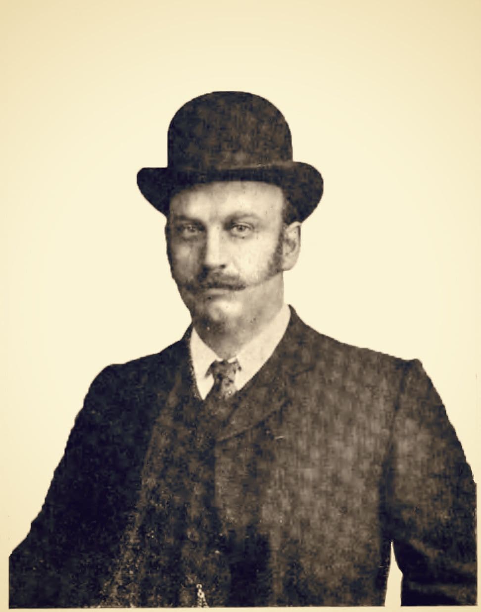 Old photograph of Herbert Austin in a bowler hat, with a moustache and long side-whiskers, wearing a jacket, collar and tie.