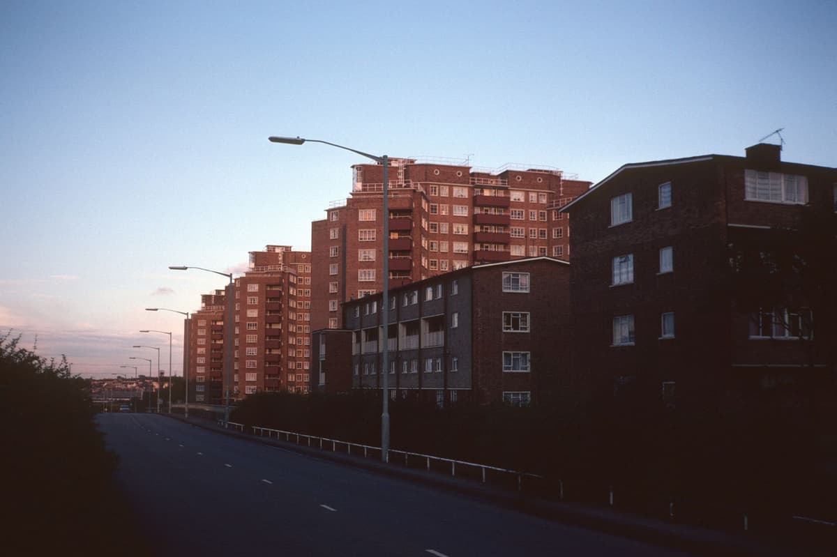 Three tall council tower blocks beside a main road.