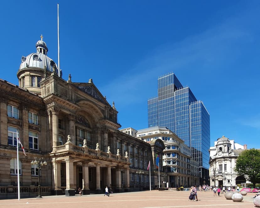 A large domed Victorian stone building with a pillared centre facing a square.