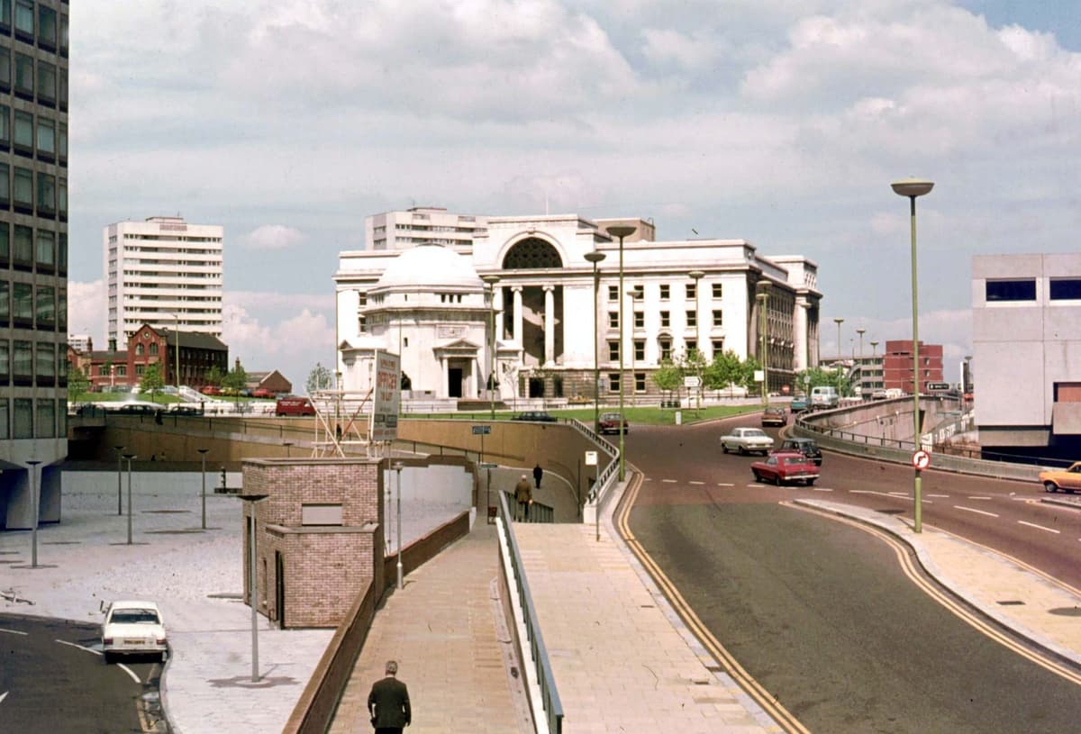 A quiet multi-lane road leading towards civic buildings.