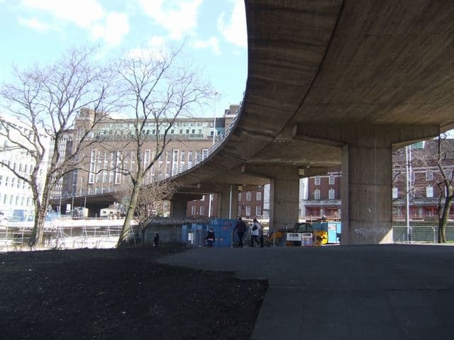 An elevated concrete road curving over a roundabout.