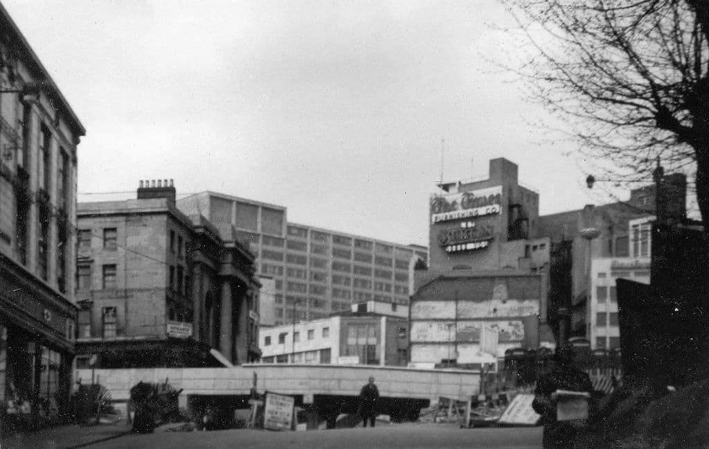 Colour photograph of Spiceal Street with a new dual carriageway cutting across between the shops and the Market Hall entrance.