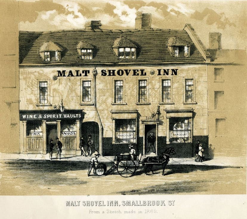 Engraving of a low old inn with a sign, between taller buildings on a town street.