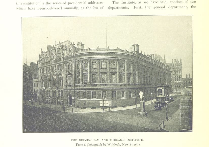 Photograph of a three-storey Renaissance building with a rounded corner, a statue in the street before it and a Gothic wing beyond.