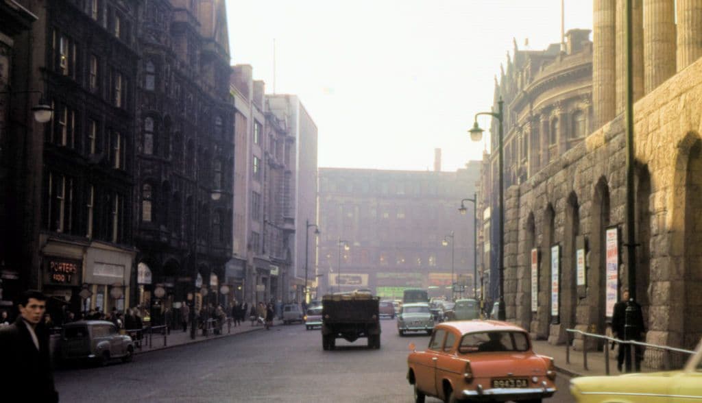 Colour street photograph with the columns of the Town Hall on the right and Victorian buildings lining the road ahead.