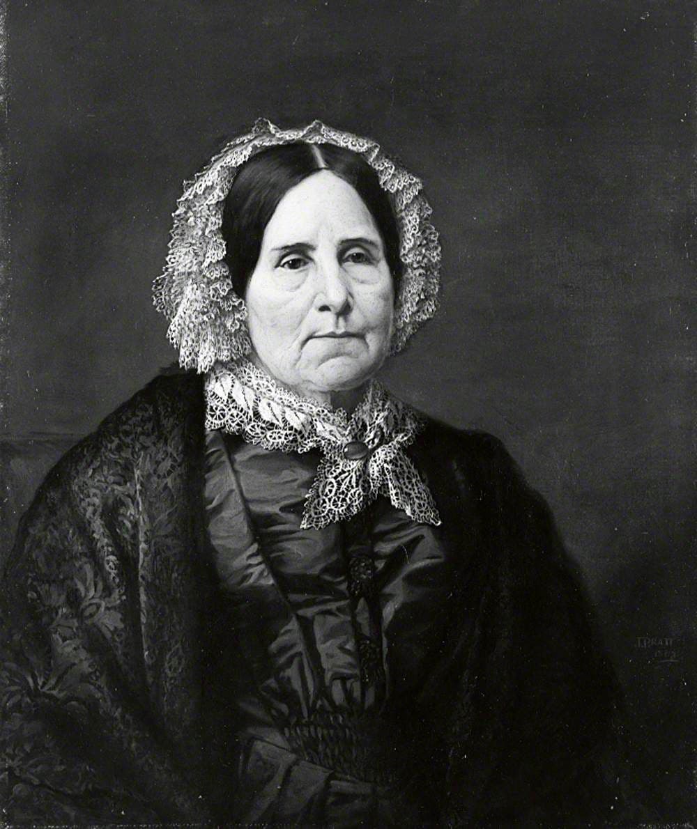 Portrait of an elderly woman in a white lace cap and a dark dress with a lace collar.