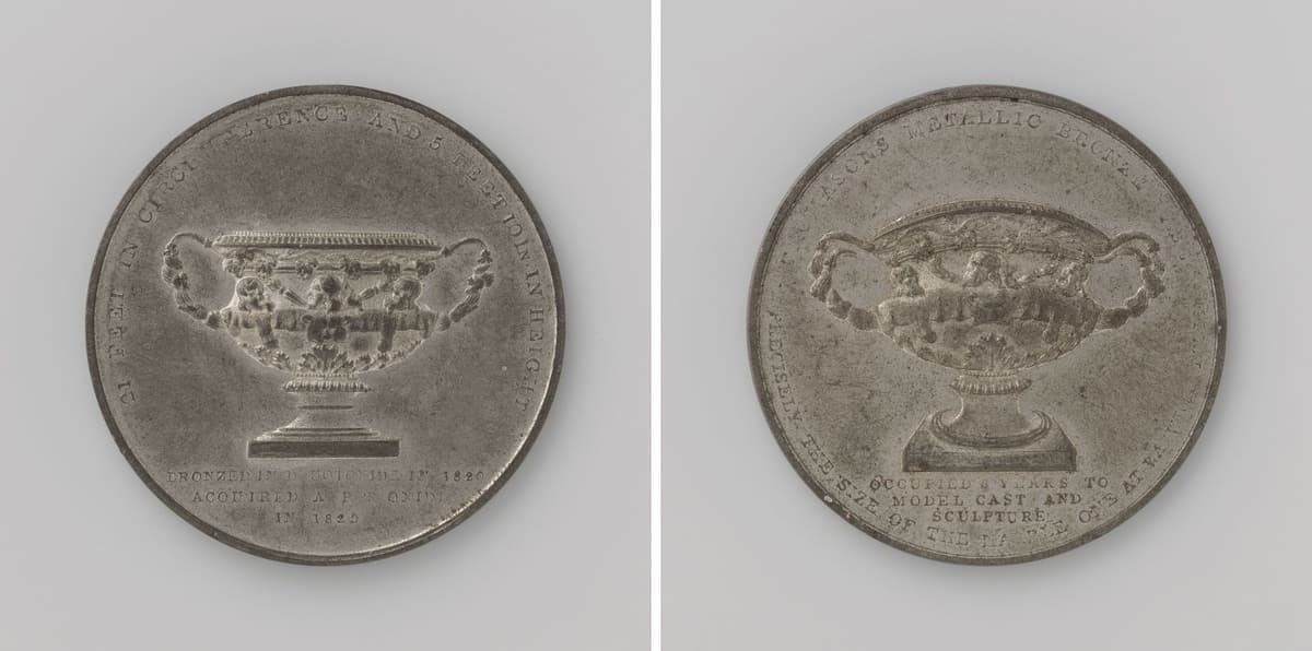 Both sides of a medal showing a large two-handled vase above an inscription.