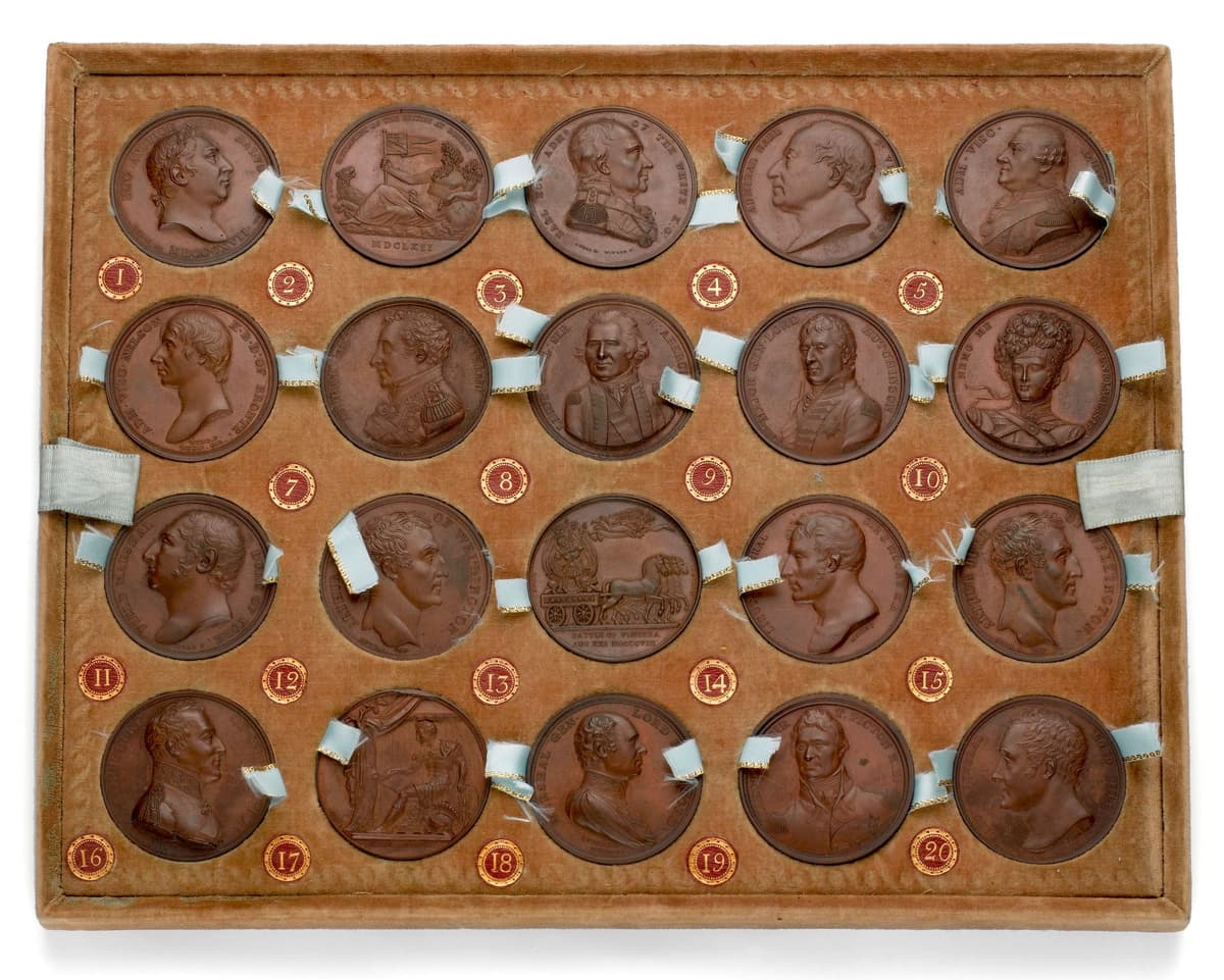 A velvet-lined tray holding twenty bronze medals in rows.