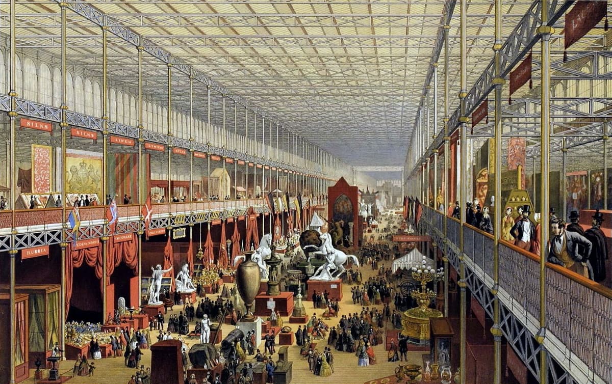 Coloured lithograph of a vast glass-roofed hall crowded with visitors and exhibits, looking towards the transept.
