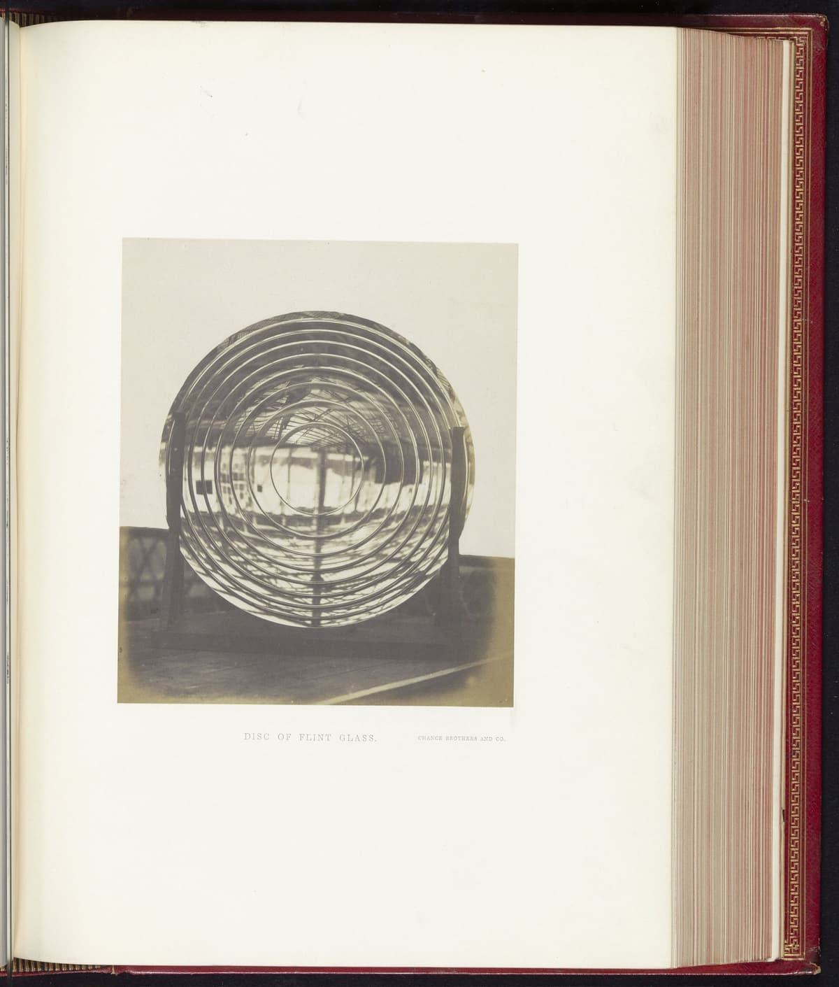 Early photograph of a large round disc of glass standing on a stand.