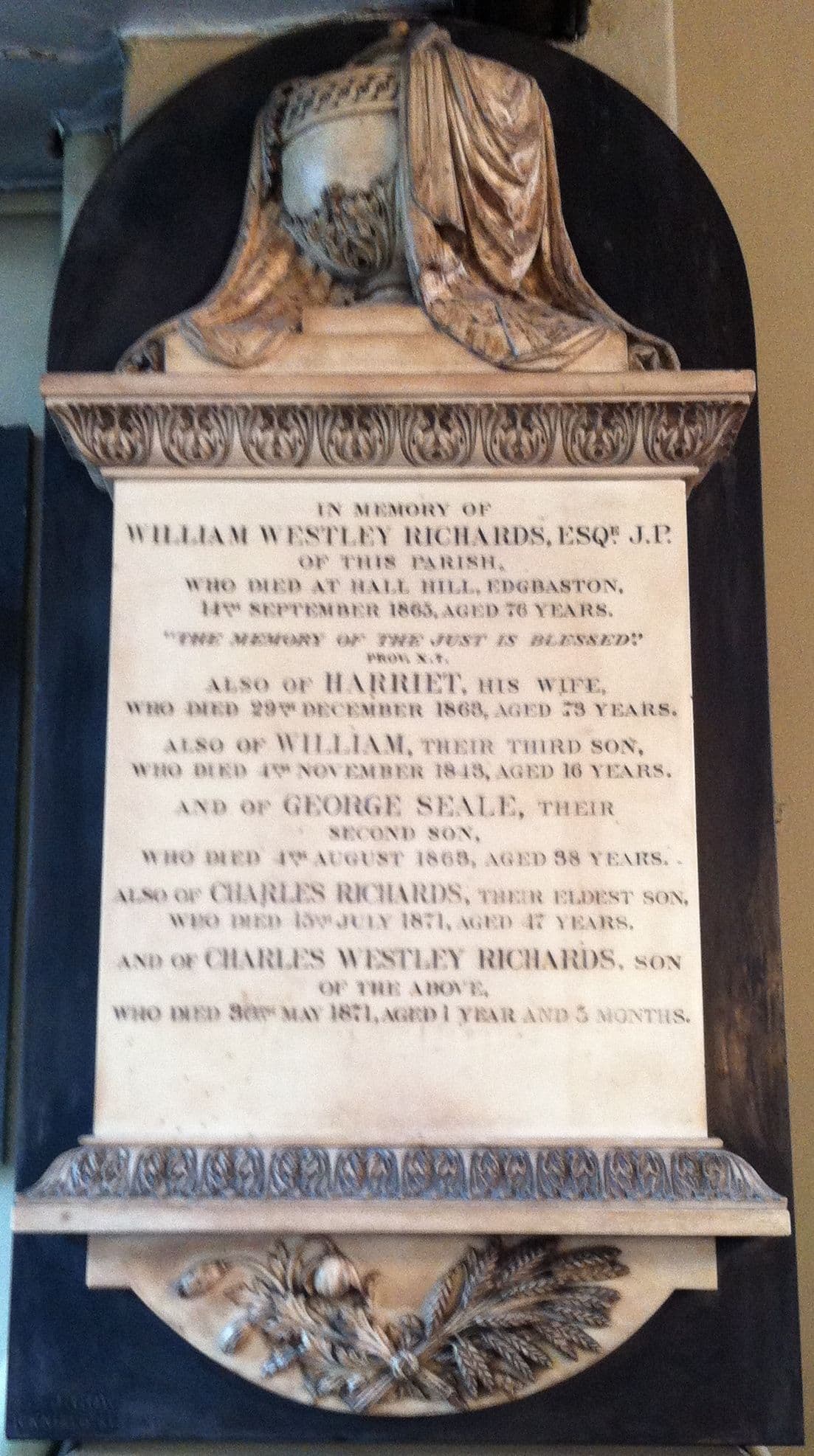 A white marble wall tablet topped by a draped urn, inscribed in memory of William Westley Richards and members of his family.