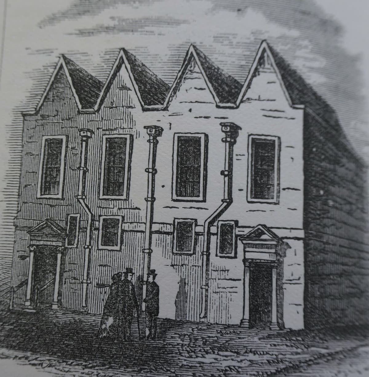 Engraving of a plain meeting house with four small gables and two pedimented doorways.