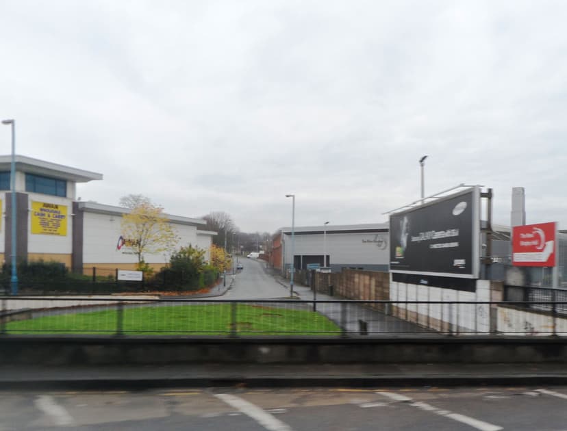 A city street of industrial buildings leading away from a large roundabout.