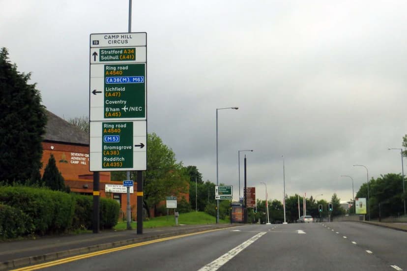 A busy road junction with traffic lights and a roundabout.