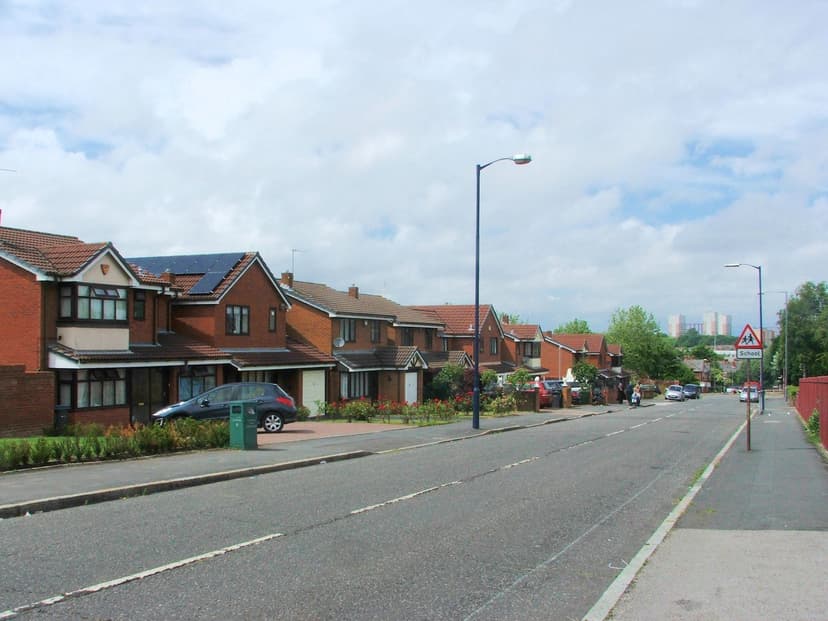 A quiet street of industrial buildings near a football ground.