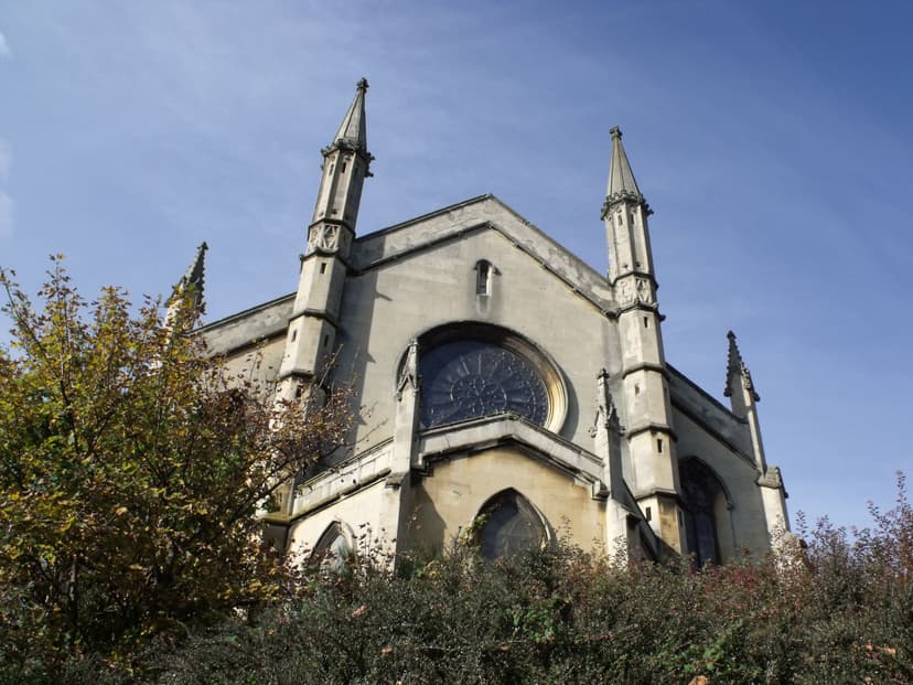 The east end of a Gothic church with a rose window between two slender pinnacled turrets.