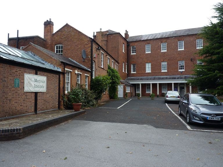 Three-storey Georgian red-brick house with sash windows and later wings around a courtyard, with a 'Maryvale Institute' sign