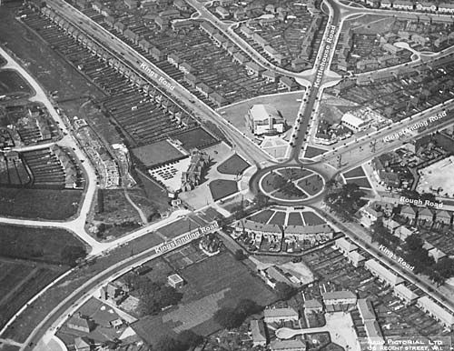 An oblique aerial photograph of Kingstanding Circle and its roundabout, with rows of new council houses. Road names are written on the print: Kings Road, Kettlehouse Road, Kingstanding Road and Rough Road. The large white Odeon stands by the Circle and the Kingstanding pub and its bowling green are in the centre. The print is marked “Aero Pictorial Ltd, 20 Regent Street, W.1”.