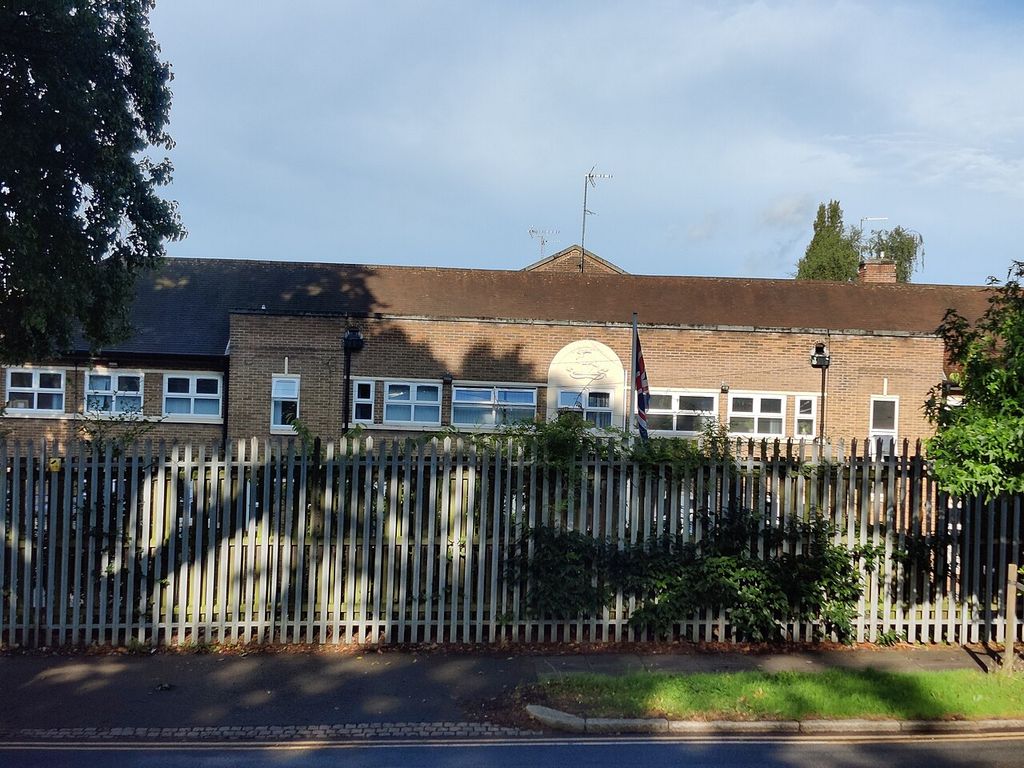 The Army Reserve Centre on Kingstanding Road seen from the road, with a white crest panel on the brick frontage behind palisade fencing.