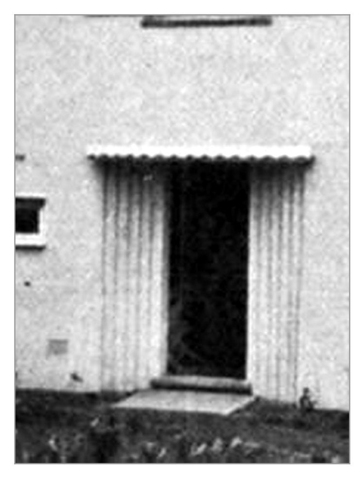 An enlarged black-and-white detail of a doorway with a scalloped canopy and a fluted rendered surround.