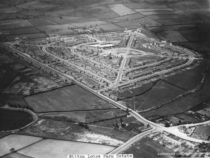 Aerial view of a new housing estate laid out in a diamond pattern of streets among fields, labelled Witton Lodge Farm Estate and Aerofilms Ltd.