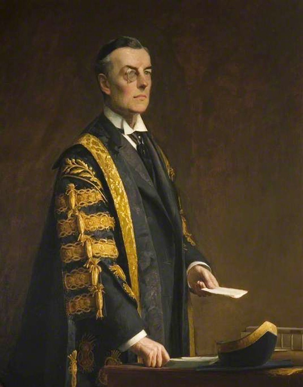 Three-quarter-length portrait of Joseph Chamberlain in black and gold ceremonial robes, wearing a monocle.