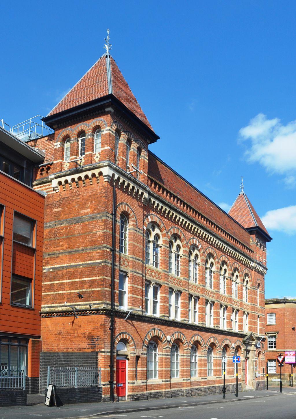 Polychrome brick factory with arcaded windows and a restored corner turret.