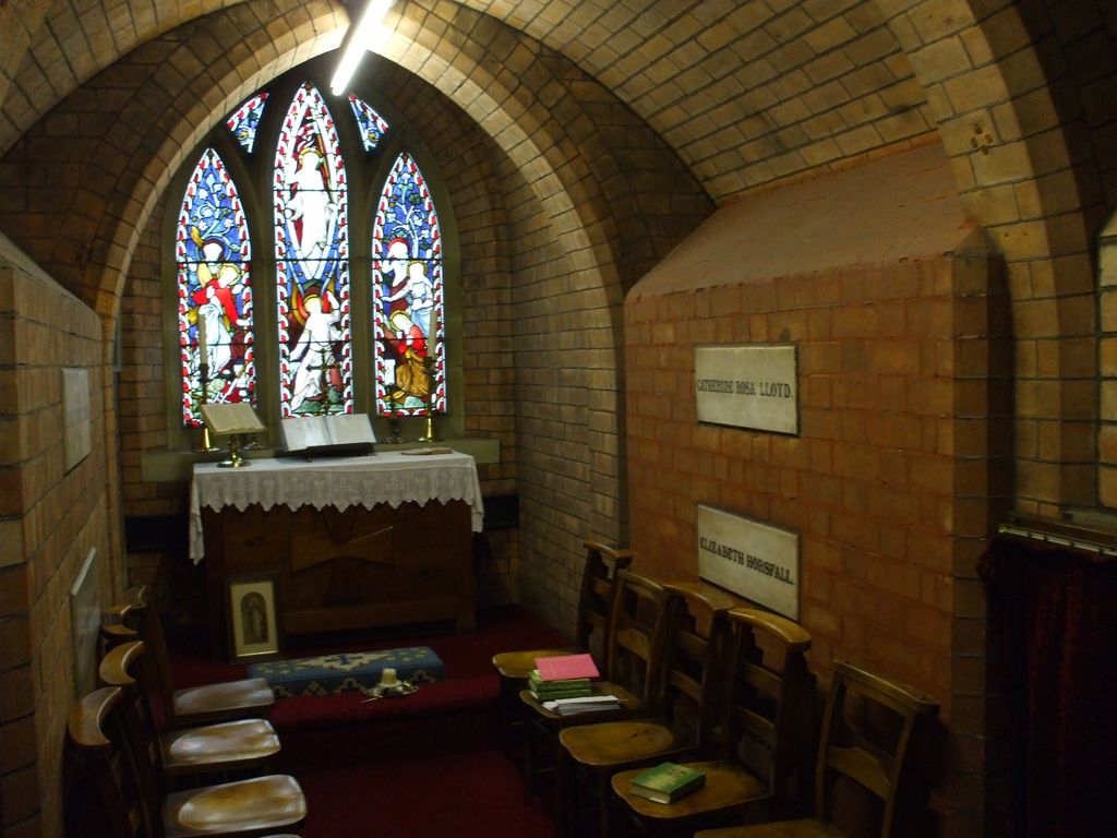 Plain brick chapel interior with stained-glass windows.