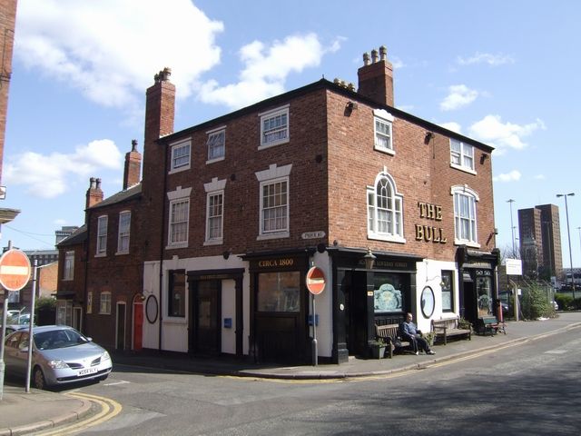 A small brick corner pub with painted signs.