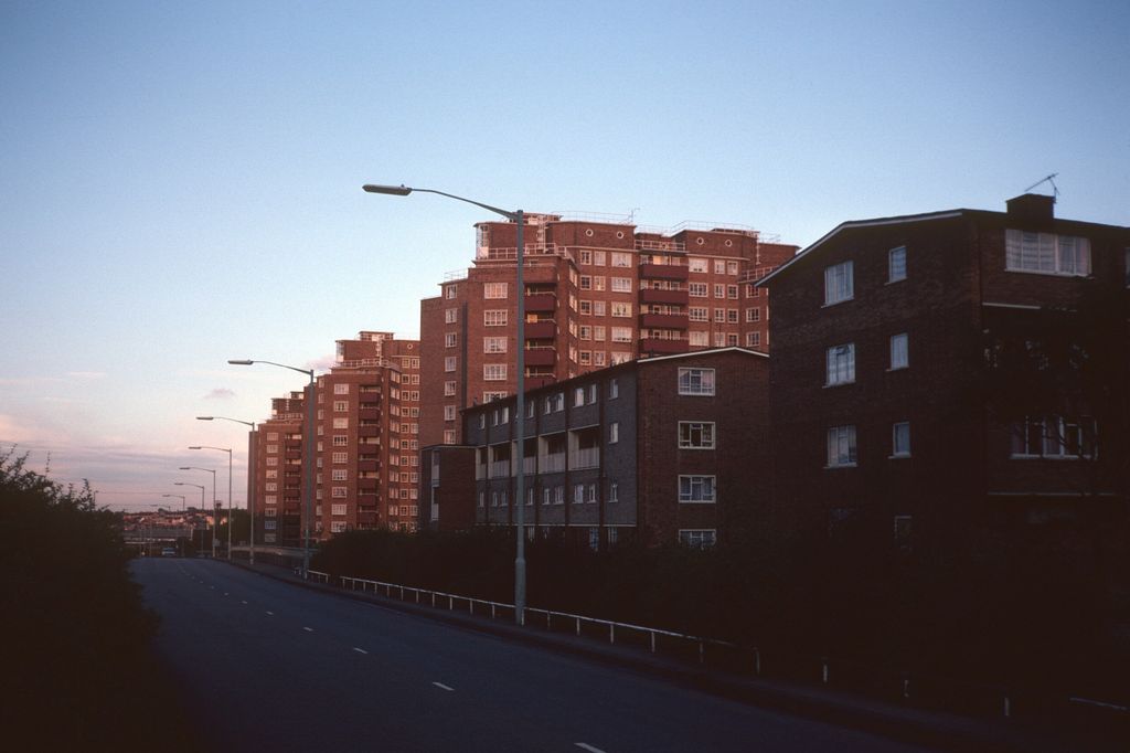 Three tall council tower blocks beside a main road.