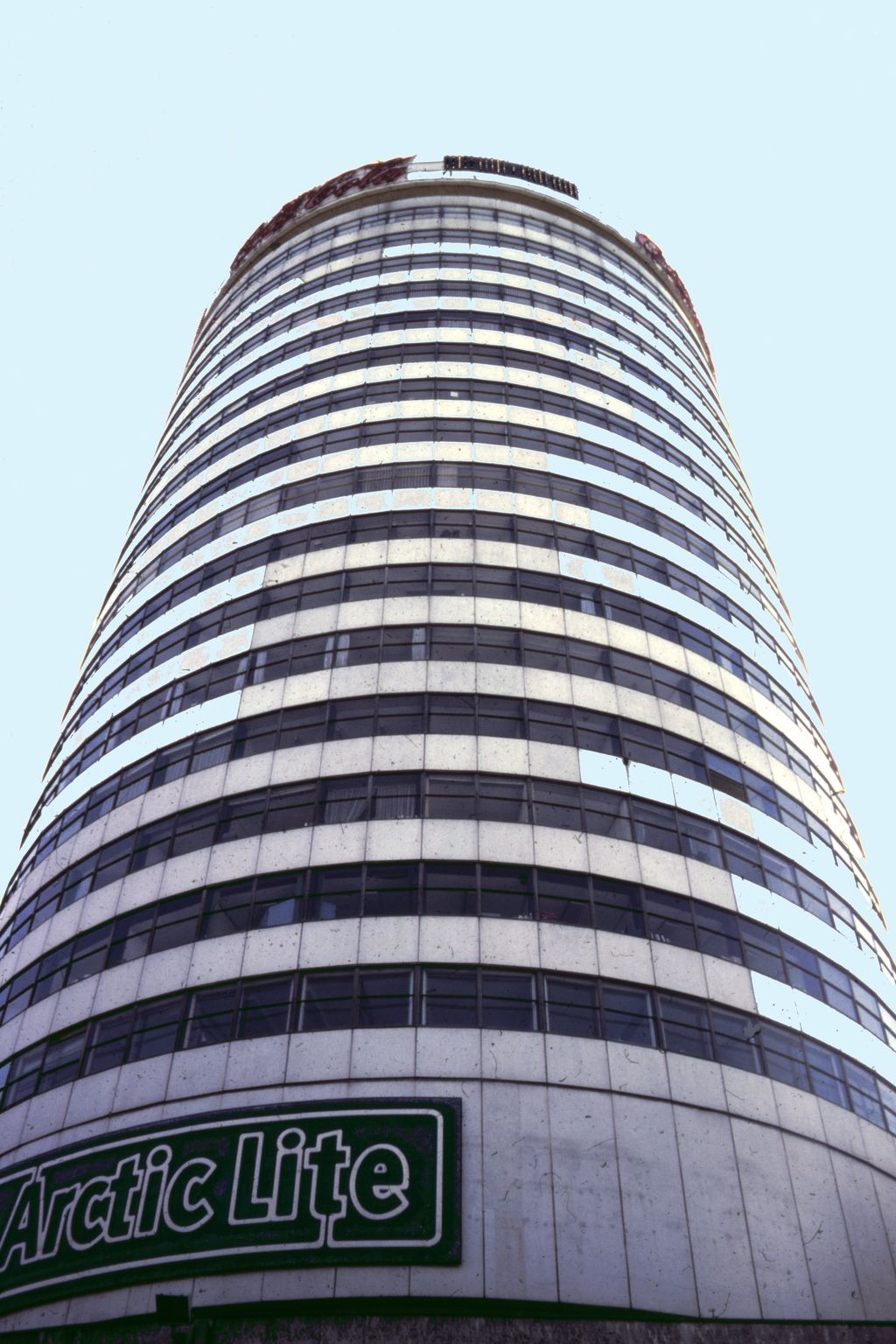 Tall cylindrical office tower against the sky.