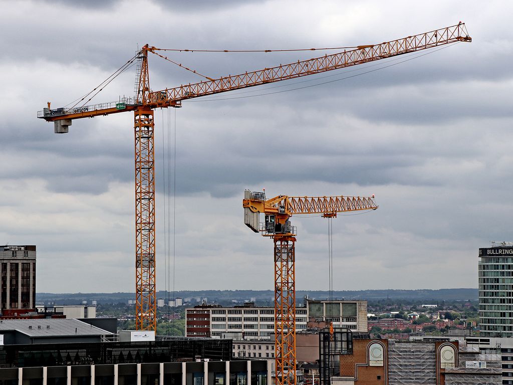 New office buildings and cranes on a city skyline.