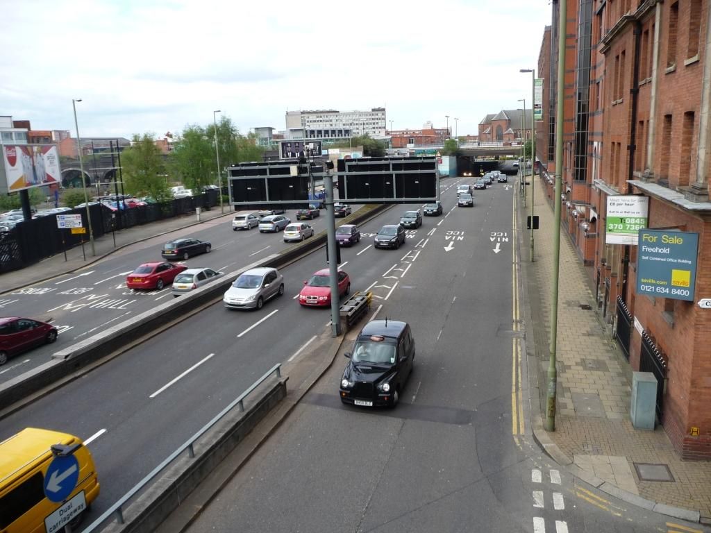 A sunken dual carriageway between city buildings.
