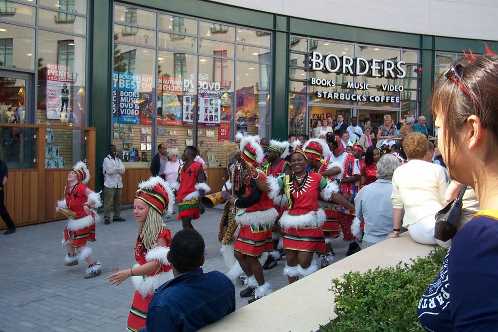 Dancers in red and white costumes perform for a crowd outside a shop front in the new Bullring.