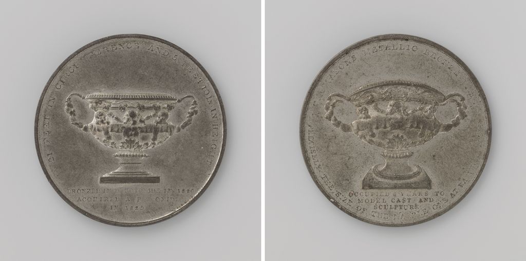 Both sides of a medal showing a large two-handled vase above an inscription.