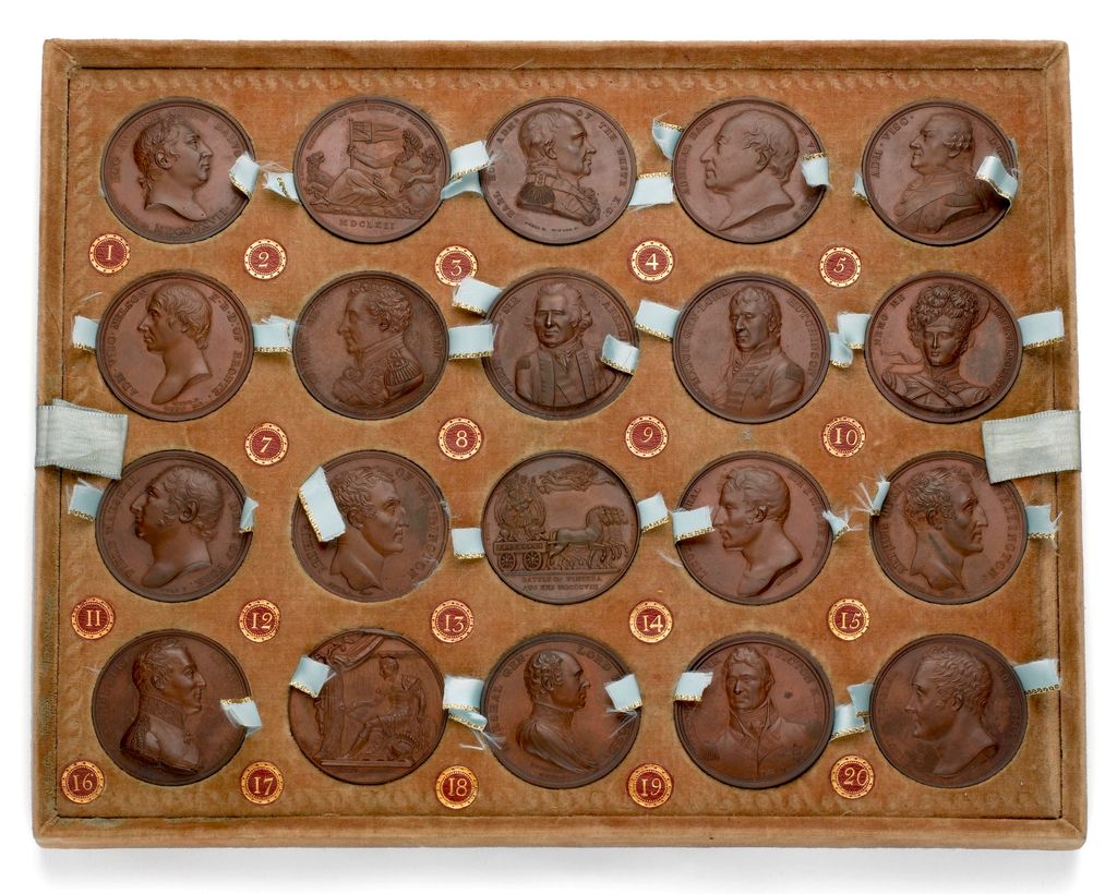 A velvet-lined tray holding twenty bronze medals in rows.